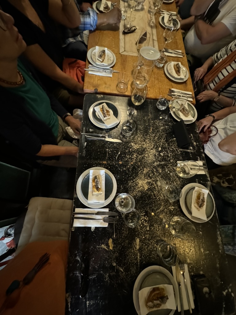 a group of people on a Lisbon food tour sitting at a table with plates and glasses